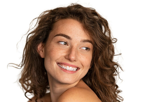 Photo of a smiling woman with brown, wavy hair